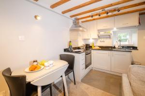 a kitchen with a table with a plate of food on it at Cherry Tree Cottage in Chapel Stile +3 photos