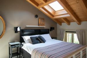 a bedroom with a large bed with a skylight at IseoLakeRental - Casa Amata in Riva di Solto