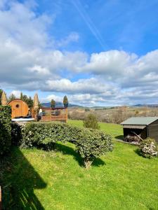 a green field with a fence and a building at Cabane Spa Sauna in Ville-sur-Jarnioux