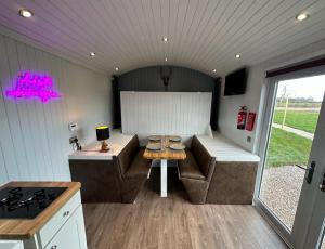 a kitchen with a couch and a table in a trailer at The Stag's Head - Shepherds Hut in Great Singleton