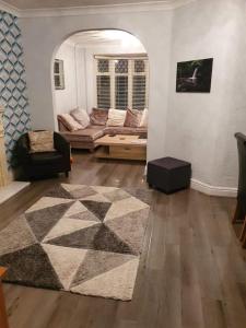 a living room with a couch and a rug at Mellte Avenue - Waterfalls House in Pont-Nedd-Fechan