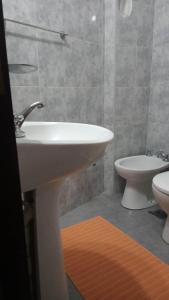 y baño con lavabo y aseo. en Complejo Arena Malva en San Bernardo