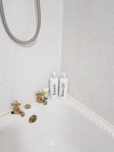 a bathroom with a sink and two toiletries on it at Mellte Avenue - Waterfalls House in Pont-Nedd-Fechan