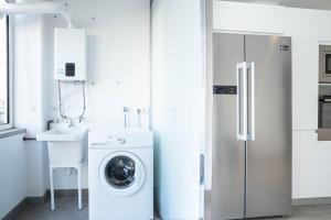 a kitchen with a washing machine and a refrigerator at GRAND TERRACE APARTMENT in Puerto de Alcudia in Alcudia