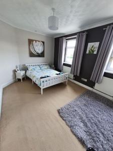 a bedroom with a bed and a rug at Mellte Avenue - Waterfalls House in Pont-Nedd-Fechan