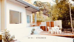 a white house with a deck with a table and chairs at Mar azul Loft in Mar Azul
