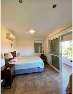 um quarto com uma cama e uma porta de vidro deslizante em Casa de Campo Luxuosa na Barragem do Capingui em Mato Castelhano