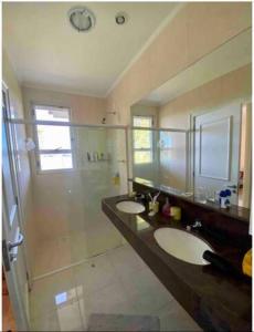 uma casa de banho com 2 lavatórios e um chuveiro em Casa de Campo Luxuosa na Barragem do Capingui em Mato Castelhano