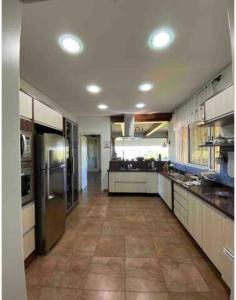 uma grande cozinha com electrodomésticos em aço inoxidável e piso em azulejo em Casa de Campo Luxuosa na Barragem do Capingui em Mato Castelhano