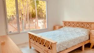 a bedroom with a wooden bed and a large window at Mar azul Loft in Mar Azul +9 photos