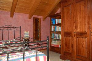 a bedroom with a bed and a book shelf with books at Narciso B&B Valbrona in Valbrona