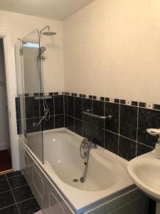 a bathroom with a bath tub and a sink at Foxborough BnB in Droichead an Chaisleáin