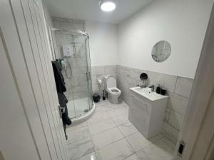 a bathroom with a shower and a toilet and a sink at Market-Side King Bed Suite in Northampton