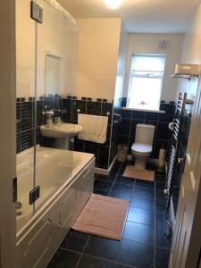 a bathroom with a tub and a sink and a toilet at Foxborough BnB in Droichead an Chaisleáin