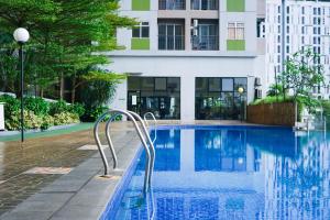 a swimming pool in front of a building at The Satu Stay - Apartemen SGV in Tangerang