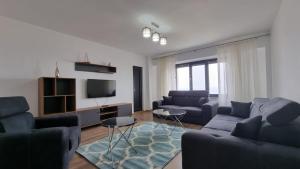 een woonkamer met 2 banken en een tv bij Amie SeaSide in Constanţa