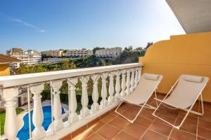 Un balcón con 2 sillas y vistas. en Don Juan apartment with pool in Carvajal Ref 98, en Fuengirola