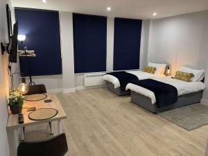 a bedroom with a bed and a table and blue walls at Market-Side King Bed Suite in Northampton