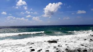 a beach with some waves and rocks in the ocean at San Giuseppe Casa per Ferie in Quercianella