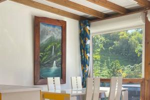 a dining room with a table and a large window at Gites de la vallée in Le Gosier