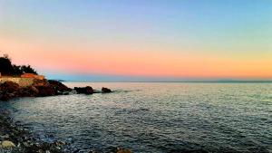 a body of water with a sunset in the background at San Giuseppe Casa per Ferie in Quercianella