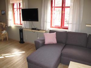 salon z szarą kanapą i różową poduszką w obiekcie Studio Na mechu-1 by Interhome w mieście Mezná