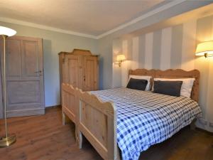 een slaapkamer met een houten bed met een blauw en wit dekbed bij Apartment Maso Dolcevista by Interhome in Lundo