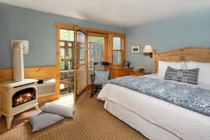 1 dormitorio con 1 cama y estufa de leña. en The Alpine House en Jackson