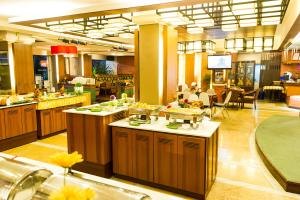 a large kitchen with a buffet line in a restaurant at Chiangmai Gate Hotel in Chiang Mai