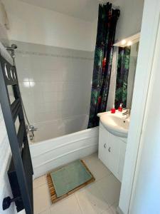 a bathroom with a tub and a sink and a shower at Appartement tout confort vue mer in Antibes