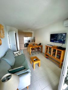 a living room with a couch and a flat screen tv at Appartement tout confort vue mer in Antibes