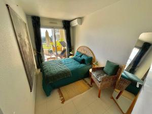a bedroom with a bed and a chair and a window at Appartement tout confort vue mer in Antibes