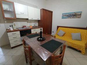 a small kitchen with a table and a bed at Sandro Apartment in Castellammare del Golfo