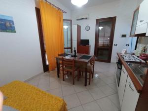 a kitchen with a table and chairs in a room at Sandro Apartment in Castellammare del Golfo