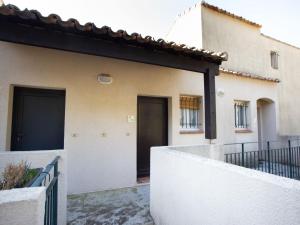 una casa con una puerta negra y una valla en Apartment Les Mas de Pramousquier-1 by Interhome, en Rayol-Canadel-sur-Mer