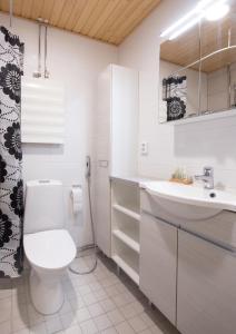 a white bathroom with a toilet and a sink at First Aparthotel Dasher in Rovaniemi