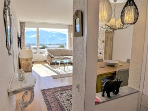 un gato negro parado en medio de una sala de estar en Apartment Jeanne d'Arc-5 by Interhome, en Crans-Montana