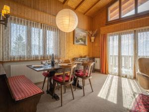 een eetkamer met een tafel, stoelen en ramen bij Apartment Plein Soleil A 10 by Interhome in Ovronnaz