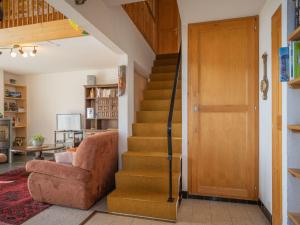 a staircase in a living room with a chair and a door at Apartment Plein Soleil A 10 by Interhome in Ovronnaz +21 photos