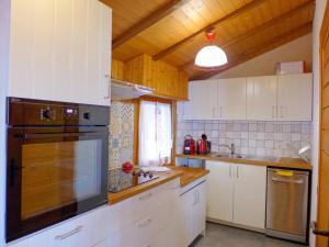 eine Küche mit weißen Schränken und einem großen Fenster in der Unterkunft Chalet Moulinettes N- 8 by Interhome in Bluche