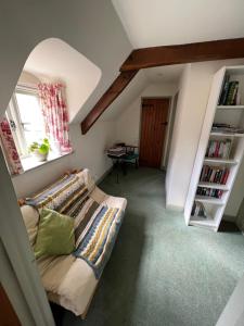 a living room with a couch and a book shelf at Delightful Pretty Cottage in Banbury