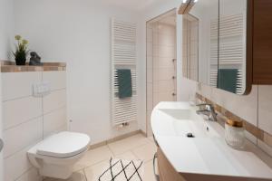 a white bathroom with a toilet and a sink at Erholung in der Natur in Moselnähe, King Size Bett, Netflix, Waschmaschine, Trockner in Bengel