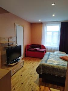 1 dormitorio con 1 cama y TV de pantalla plana en Ventspils Apartments, en Ventspils