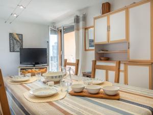 a kitchen with a table with bowls and plates on it at Apartment Les Maisons de l'Océan-9 by Interhome in Lacanau-Océan