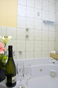 a bottle of wine and two glasses on a bath tub at Victoria Hotel Strathalbyn in Strathalbyn