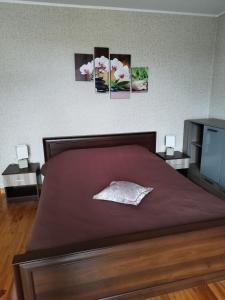 1 dormitorio con 1 cama con 3 cuadros en la pared en Ventspils Apartments, en Ventspils
