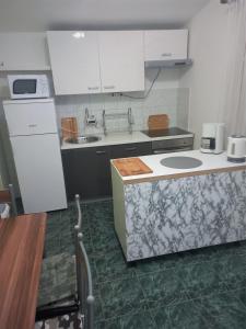 a kitchen with white cabinets and a green floor at Apartments Samaržija- new 63 not 47 in Bibinje