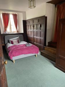 安斯蒂的住宿－Higher Melcombe Manor，一间卧室配有一张带粉红色棉被的床