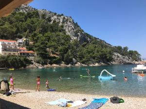 a group of people in the water at a beach at Apartments Apollo in Zastražišće