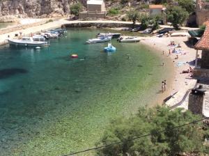 a group of people on a beach with boats in the water at Apartments Apollo in Zastražišće